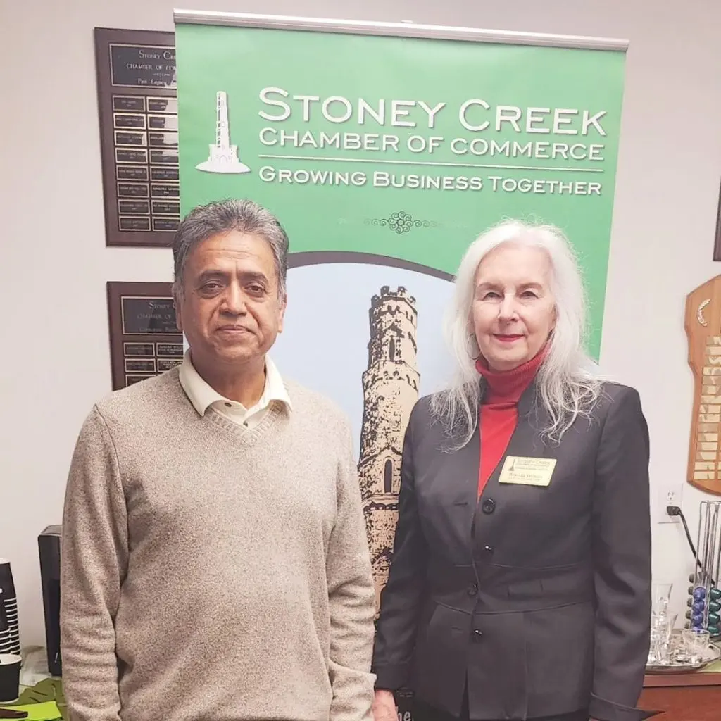 A PCBO member and a Chamber representative in front of the Chamber banner